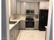 Kitchen with gray cabinetry, stainless steel appliances, and white countertops at 2638 W Sat Nam Way, Phoenix, AZ 85086