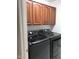 Convenient laundry room with dark, front load washer and dryer and upper cabinets at 2638 W Sat Nam Way, Phoenix, AZ 85086