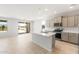 Open-concept kitchen with a large island, neutral cabinets, stainless steel appliances, and tile flooring at 26995 W Adam Ave, Buckeye, AZ 85396