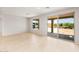 Bright living room featuring tile flooring, large window, and glass slider to a covered patio at 26995 W Adam Ave, Buckeye, AZ 85396