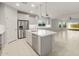 Open kitchen with stainless steel appliances, center island with breakfast bar, and seamless flow to living spaces at 6247 W Georgetown Way, Florence, AZ 85132