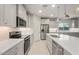 Modern kitchen featuring sleek stainless steel appliances, white cabinetry, and quartz countertops at 6247 W Georgetown Way, Florence, AZ 85132