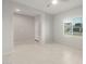 Open living room with tiled floors, neutral color palette, and large window for natural light at 6247 W Georgetown Way, Florence, AZ 85132