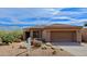 Front view of a cozy home with desert landscaping and a two-car garage at 6827 E Eagle Feather Rd, Scottsdale, AZ 85266