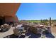 Outdoor patio with desert landscape views, chairs, tables, and a modern fireplace at 6827 E Eagle Feather Rd, Scottsdale, AZ 85266