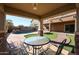 Inviting backyard with artificial turf, pool with waterfall feature, and shaded patio at 10037 W Chipman Rd, Tolleson, AZ 85353