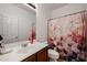 Bathroom with a sink, toilet, and patterned shower curtain, offering a private and functional space at 10037 W Chipman Rd, Tolleson, AZ 85353