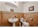 Powder room with decorative tile accent, pedestal sink, and a toilet, offering a convenient space at 10037 W Chipman Rd, Tolleson, AZ 85353