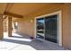 View of the covered patio with concrete floor and sliding glass doors to the backyard at 10037 W Chipman Rd, Tolleson, AZ 85353