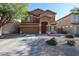 Charming two-story home with a well-maintained lawn, mature tree, and desert landscaping at 10037 W Chipman Rd, Tolleson, AZ 85353