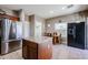 Eat-in kitchen with tile floors, stainless steel refrigerator, kitchen island, and breakfast table at 10037 W Chipman Rd, Tolleson, AZ 85353