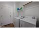 Well-organized laundry room equipped with a washer and dryer, with shelving for storage at 10037 W Chipman Rd, Tolleson, AZ 85353