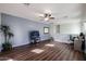 Bright living room with hardwood floors, ceiling fan, and a view into the office space at 10037 W Chipman Rd, Tolleson, AZ 85353