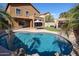 Relax in this backyard oasis featuring a refreshing pool, outdoor seating, and manicured landscaping at 10037 W Chipman Rd, Tolleson, AZ 85353