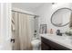 Cozy bathroom showcasing a vanity with a round mirror, neutral shower curtain, and updated fixtures at 10241 E La Palma Ave, Gold Canyon, AZ 85118
