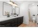 Modern bathroom featuring double sinks with black fixtures, dark cabinets, and stylish mirrors at 10241 E La Palma Ave, Gold Canyon, AZ 85118