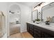 Contemporary bathroom vanity with dual sinks, sleek black fixtures, and view to carpeted bedroom at 10241 E La Palma Ave, Gold Canyon, AZ 85118