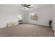 Neutral bedroom boasts plush carpet, ceiling fan, and sunny window at 10241 E La Palma Ave, Gold Canyon, AZ 85118