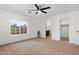 Spacious bedroom with ceiling fan features neutral carpet and arched doorway at 10241 E La Palma Ave, Gold Canyon, AZ 85118