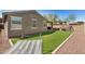 Well-maintained backyard with low-maintenance turf, paver accents, and covered patio for relaxation and entertainment at 10454 W Maya Way, Peoria, AZ 85383