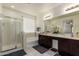 Bright bathroom with double sinks, granite countertops, soaking tub, and glass-enclosed shower at 10454 W Maya Way, Peoria, AZ 85383