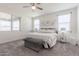 Bright and airy bedroom with a ceiling fan, plush gray carpeting, and three windows for natural light at 10454 W Maya Way, Peoria, AZ 85383