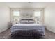 Comfortable bedroom with neutral colors, soft carpet, ceiling fan, and decorative accents at 10454 W Maya Way, Peoria, AZ 85383