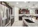 Well-equipped kitchen featuring stainless steel appliances, granite countertops, dark wood cabinets, and large island at 10454 W Maya Way, Peoria, AZ 85383