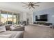 Spacious living room with a large sectional sofa, plush carpeting, and natural light at 10454 W Maya Way, Peoria, AZ 85383