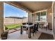 Cozy covered patio area featuring outdoor table and chairs, with views of the manicured backyard and privacy wall at 10454 W Maya Way, Peoria, AZ 85383