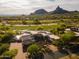 Aerial view showcasing the home, manicured golf course, and the desert mountains at 10596 E Yearling Dr, Scottsdale, AZ 85255