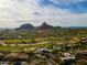 A sprawling community with lush green golf courses nestled among beautiful desert mountains under a blue sky at 10596 E Yearling Dr, Scottsdale, AZ 85255