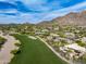 Panoramic aerial view showcasing desert community, golf course, and homes nestled in the rocky desert landscape at 10596 E Yearling Dr, Scottsdale, AZ 85255