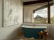 Relaxing bathroom featuring a soaking tub with a view of Pinnacle Peak and a nearby window at 10596 E Yearling Dr, Scottsdale, AZ 85255