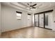 Spacious bedroom with wood floors, ample natural light, and a modern ceiling fan fixture at 10596 E Yearling Dr, Scottsdale, AZ 85255