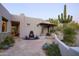 Beautiful home exterior featuring a tranquil fountain, desert landscaping, covered patio, and mature cactus at 10596 E Yearling Dr, Scottsdale, AZ 85255