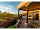 Exterior shot features a covered porch with desert landscaping, and distant mountain and golf course views at 10596 E Yearling Dr, Scottsdale, AZ 85255