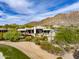 Beautiful exterior view of desert home featuring manicured landscaping, vibrant flowers, and native cacti at 10596 E Yearling Dr, Scottsdale, AZ 85255