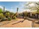 Southwestern home featuring a paved driveway, lush desert landscaping with mature cacti and drought-tolerant shrubs at 10596 E Yearling Dr, Scottsdale, AZ 85255