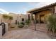 Inviting front entrance with a tiled roof, stone accents, desert landscaping, and secure gate at 10596 E Yearling Dr, Scottsdale, AZ 85255