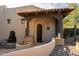 Charming arched doorway with stone accents and a serene water fountain, creating a welcoming entrance at 10596 E Yearling Dr, Scottsdale, AZ 85255