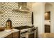 Gourmet kitchen with designer tile backsplash, stainless steel hood, and professional grade range at 10596 E Yearling Dr, Scottsdale, AZ 85255