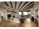 Spacious living room with beamed ceilings, stone fireplace, hardwood floors, and expansive windows with natural light at 10596 E Yearling Dr, Scottsdale, AZ 85255