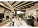 Inviting living room with exposed beams, a stone fireplace, and expansive windows offering picturesque views at 10596 E Yearling Dr, Scottsdale, AZ 85255