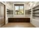 Charming office area with built-in shelves, storage cabinets, wood floors, and a window view at 10596 E Yearling Dr, Scottsdale, AZ 85255
