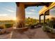 Cozy outdoor patio with a stone fireplace and scenic views of the surrounding golf course at 10596 E Yearling Dr, Scottsdale, AZ 85255