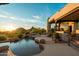Relaxing poolside oasis with a waterfall feature, lush landscaping, and scenic mountain views at 10596 E Yearling Dr, Scottsdale, AZ 85255