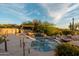 Outdoor pool and hot tub feature a waterfall, desert landscaping and mountain views in the background at 10596 E Yearling Dr, Scottsdale, AZ 85255