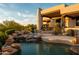 Inviting pool area with rock waterfall, lush landscaping, and desert mountain views perfect for relaxation at 10596 E Yearling Dr, Scottsdale, AZ 85255
