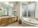 Elegant bathroom features a jacuzzi tub, large vanity, tile flooring and unique glass block window at 11320 N Crestview Dr, Fountain Hills, AZ 85268